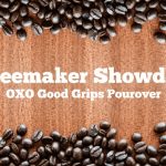 An image reading "Coffeemaker Showdown: OXO Good Grips Pourover". The image is lined with coffee beans on a wood background.
