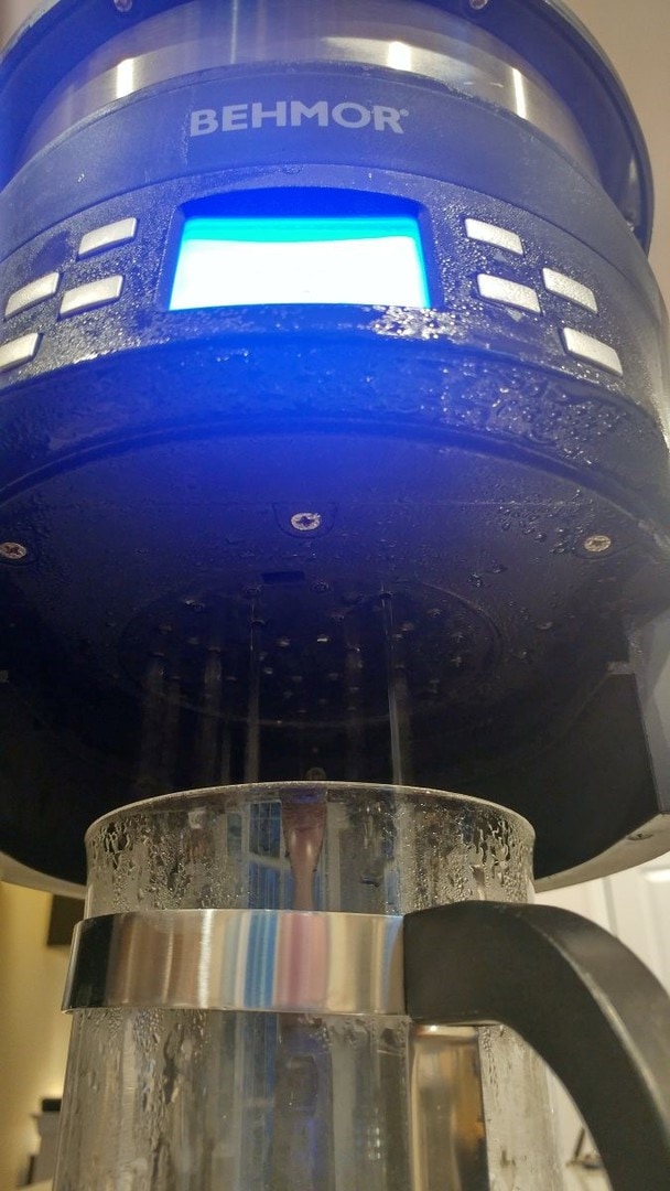The Behmor Brazen Plus in manual mode, dispensing hot water into a French press. Condensation is forming all over the front control panel and LCD display.
